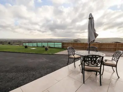 a table and chairs and an umbrella on a patio at Border View Lodge in Welshpool