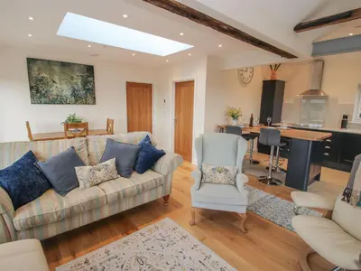 a living room with a couch and a kitchen at Border View Lodge in Welshpool