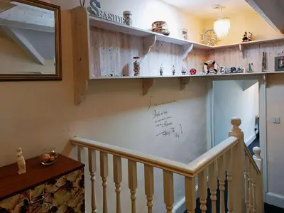 a room with a staircase with a whiteboard on the wall at Trem Y Mor - Edge of the Sea in Tywyn