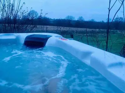 a jacuzzi tub with a heater in it at Ysgubor y Tanybryn The barn with a view and a spa. in Tregaron