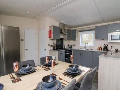 a kitchen and dining room with a table and chairs at 43 The Deri in New Quay