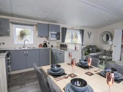 a kitchen and a living room with a table and a kitchen at 43 The Deri in New Quay