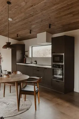 a kitchen with a table and a wooden ceiling at 3 x bespoke built cabins with hot tubs, mid Wales in Newtown
