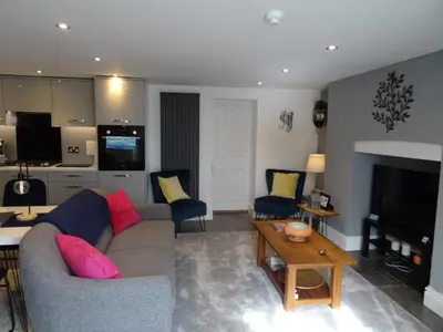 a living room with a couch and a table at Ty Ni Holiday Apartment Aberdovey in Aberdyfi