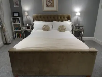 a large bed in a bedroom with two night stands at Ty Ni Holiday Apartment Aberdovey in Aberdyfi