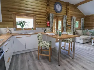 a kitchen and living room with a table and chairs at Redwood Lodge in Ellesmere