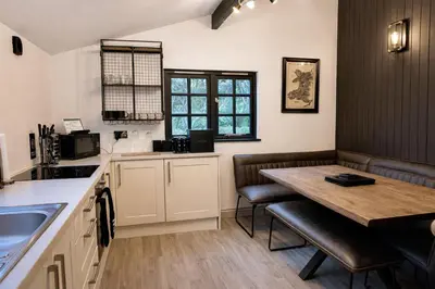 a kitchen with a table and chairs and a sink at Glandwr Lodge, 3 bed in Barmouth, Wales in Barmouth