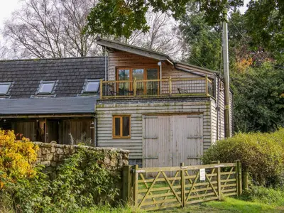 a wooden house with a balcony on top of it at The Chicken Coop in Shrewsbury