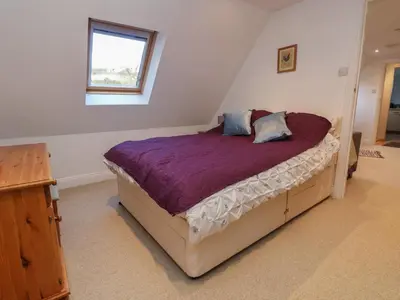a bedroom with a bed with purple sheets and a window at The Chicken Coop in Shrewsbury