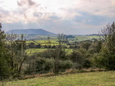 a view of a field with a mountain in the distance at The Duckhouse in Shrewsbury