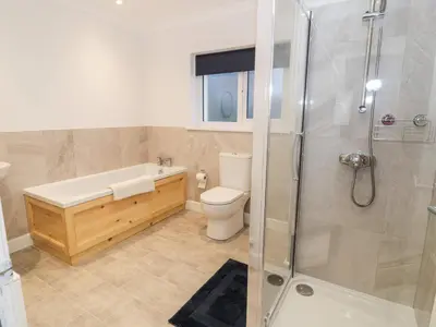 a bathroom with a tub and a toilet and a shower at Borthwen in Barmouth