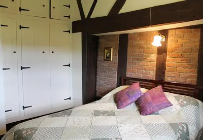 a bedroom with a bed and two white cabinets at Cider Press in Hereford