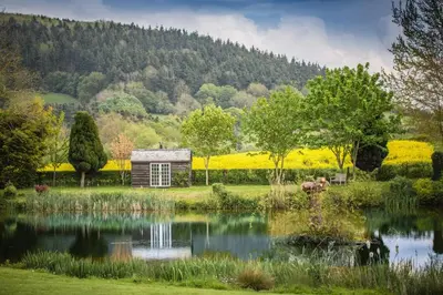 a garden with a pond in front of a building at Cider Press in Hereford