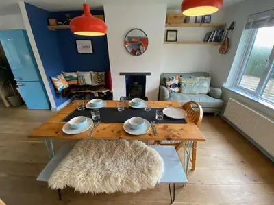 a living room with a table and a couch at Bungalow, mountain and sea views parking in Aberdyfi