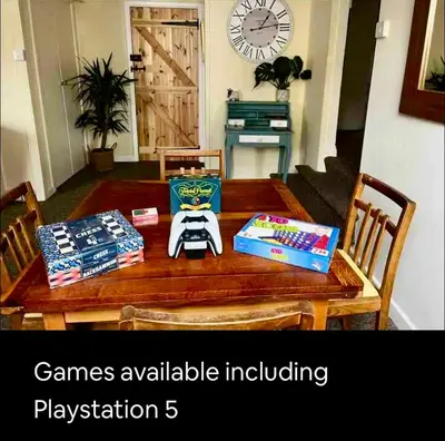 a wooden table with games available including playstation at Kookaburra lodge in Brecon