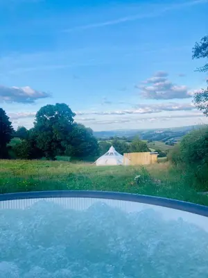 a swimming pool in a field with a tent at Luxury Stargazing Glamping - Seren Aur with Hot Tub in Llanidloes
