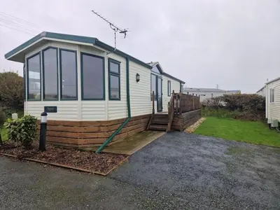 a house with a hose on the side of it at Harries Lodge ocean in New Quay