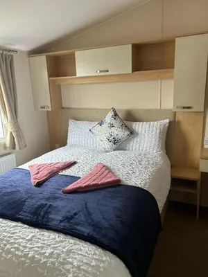 a bedroom with a bed with two towels on it at Harries Lodge 2 Aberaeron in Aberaeron
