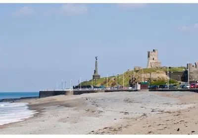 a view of the beach with a castle in the background at Experience Coastal Bliss in Our Modern 2019 Sea Viev 2 Bedroom static caravan at Clarach Bay Holiday Village! in Aberystwyth