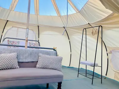 a bed in a tent with a chair in it at Luxury Stargazing Glamping - Seren Hardd with Hot Tub in Llanidloes