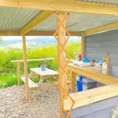 a wooden pergola with a table and a bench at Luxury Stargazing Glamping - Seren Hardd with Hot Tub in Llanidloes