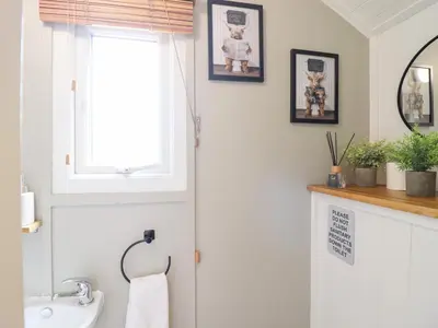 a bathroom with a sink and a window at Red Kite at Wild Valley Huts in Oswestry