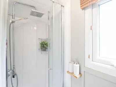a shower with a glass door in a bathroom at Red Kite at Wild Valley Huts in Oswestry