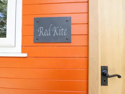 a sign on the side of a orange house at Red Kite at Wild Valley Huts in Oswestry