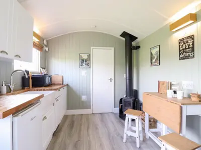 a kitchen with white cabinets and a stove at Cuckoo at Wild Valley Huts in Oswestry