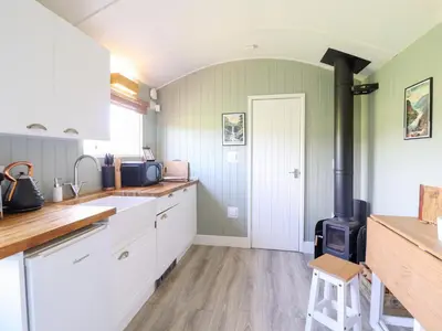 a kitchen with a stove in the middle at Cuckoo at Wild Valley Huts in Oswestry