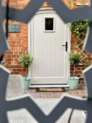 a white door with potted plants in front of a house at The Old Rectory Tack Rooms in Shrewsbury