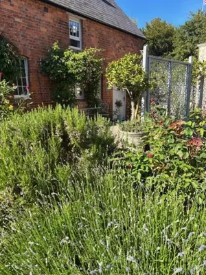 a garden in front of a brick house at The Old Rectory Tack Rooms in Shrewsbury