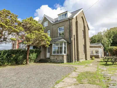 a large brick house with a tree in front of it at Tawelfan in Llwyngwril