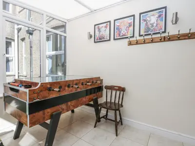 a glass desk in a room with a chair at Tawelfan in Llwyngwril