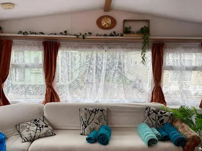 a white couch in a living room with a window at The fox den in Rhos-gôch