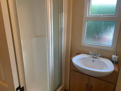 a bathroom with a sink and a window at The fox den in Rhos-gôch