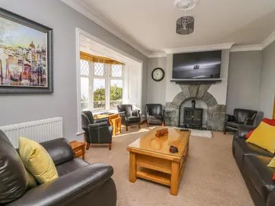 a living room with a couch and a fireplace at Mynydd ar Mor in Barmouth