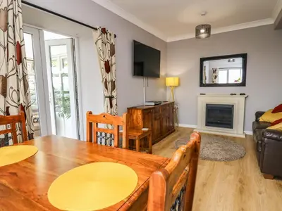 a living room with a wooden table and a couch at Mynydd ar Mor in Barmouth
