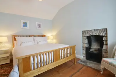 a bedroom with a bed and a fireplace at Y Bwthyn Aberaeron in Aberaeron