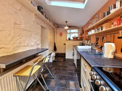 a kitchen with a counter and some chairs in it at Arwel Llangrannog in Llanllwchaiarn