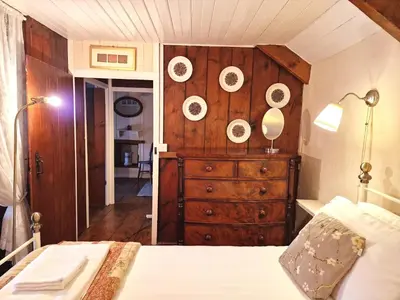 a bedroom with a dresser with plates on the wall at Arwel Llangrannog in Llanllwchaiarn