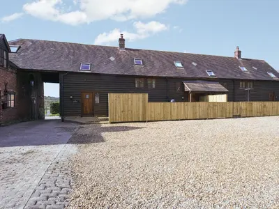 a barn with a wooden fence in front of it at Uk46578 - Drifthouse in Church Stretton