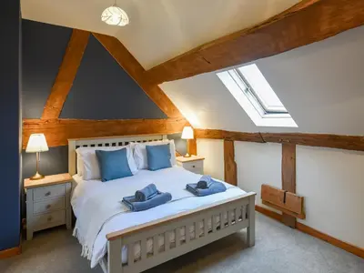 a bedroom with a bed with blue pillows on it at Uk46578 - Drifthouse in Church Stretton