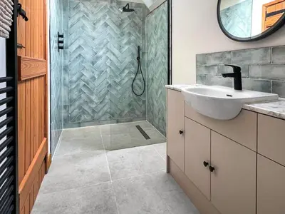 a bathroom with a sink and a shower with a mirror at Uk46578 - Drifthouse in Church Stretton
