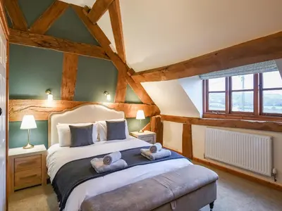 a bedroom with a large bed with two towels on it at Uk46578 - Drifthouse in Church Stretton