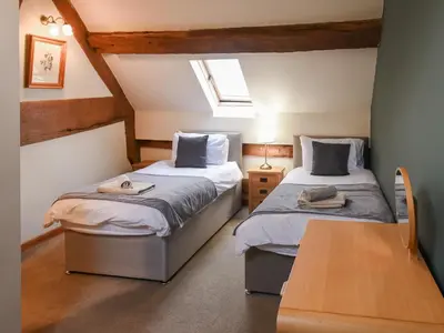 a bedroom with two beds and a table at Uk46578 - Drifthouse in Church Stretton