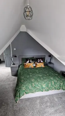 a bedroom with a bed with pillows on it at The Penthouse NY Loft Apartment in Barmouth