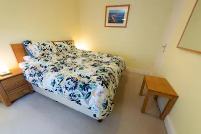 a bedroom with a bed with a blue and white bedspread at Plas Hafan Apartment 2 Aberystwyth in Aberystwyth