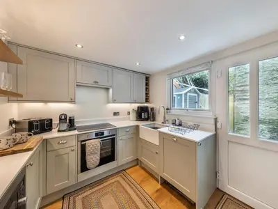 a kitchen with white cabinets and a window at 4 Bed in Aberdovey 94232 in Aberdyfi