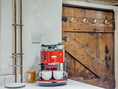 a red coffee maker sitting on a counter with two cups at 2 Bed in Brecon oc-92729 in Brecon